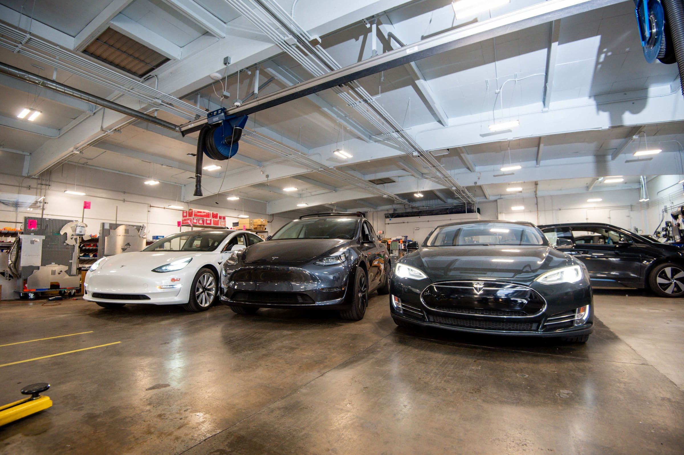 Four Teslas lined up across the Earthling floor under the exhaust reels